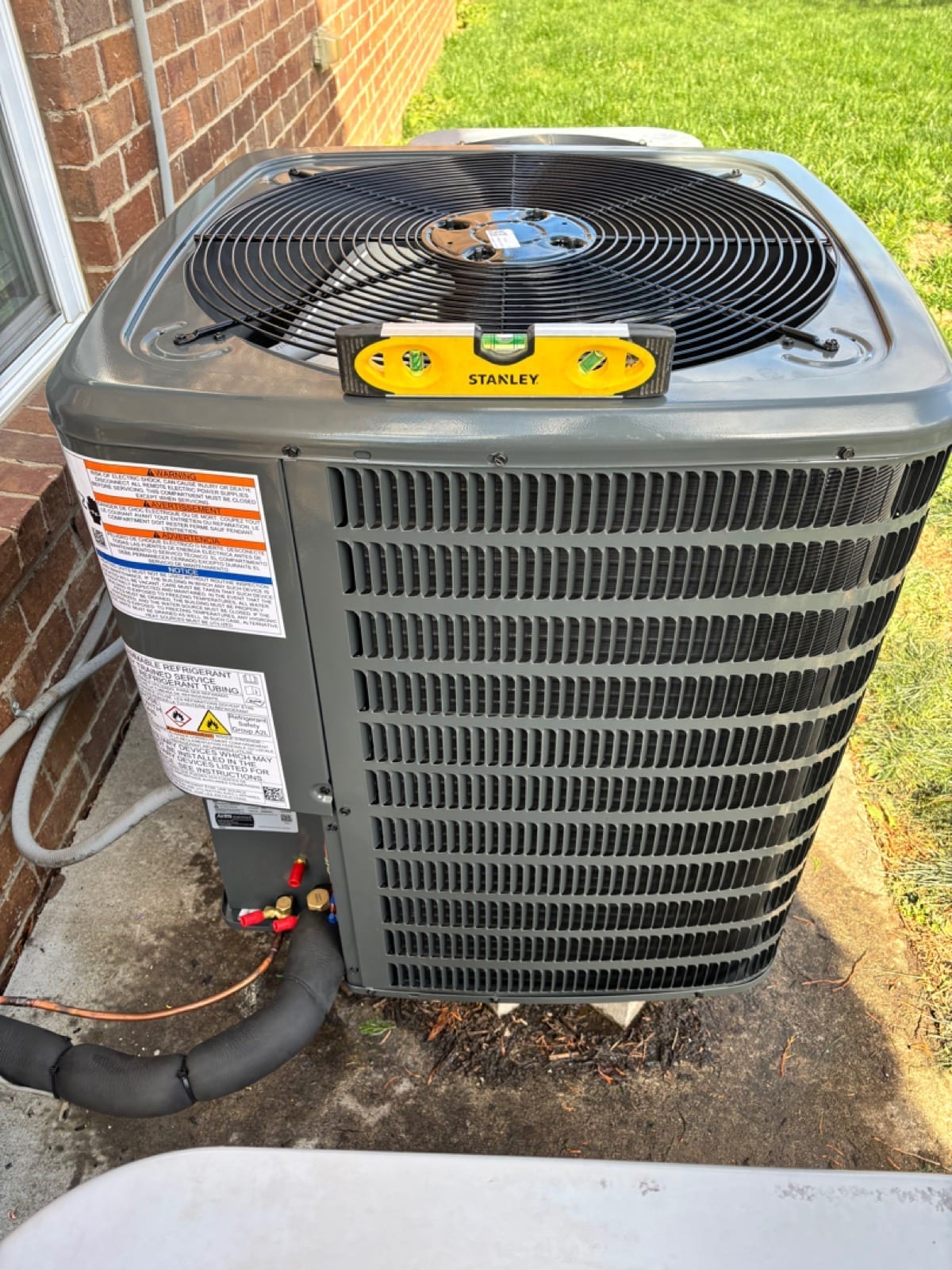 American Standard AC condenser professionally installed on a level pad beside a Lexington home